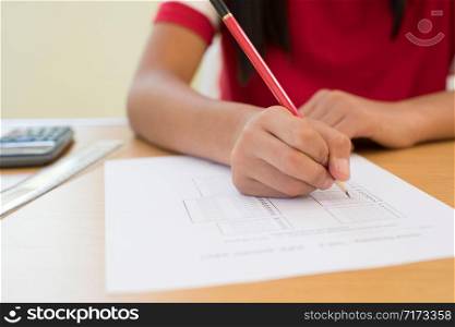 Close Up Of Female Pupil Taking Multiple Choice Examination Paper