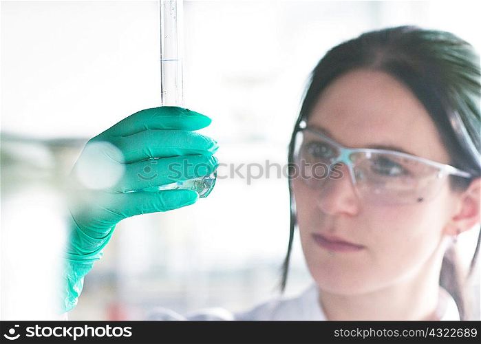 Close up of female scientist examining at test tube