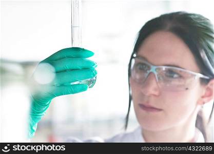 Close up of female scientist examining at test tube