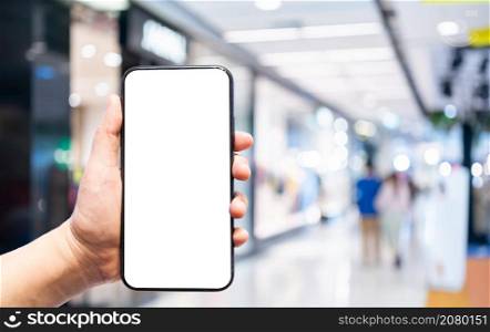 Close-up of female use Hand holding smartphone with empty blank white screen blurred images touch of Abstract blur of inside shopping complex background,shopping online concept.