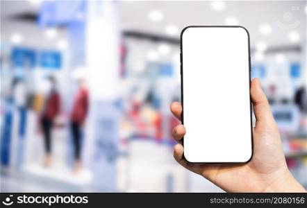 Close-up of female use Hand holding smartphone with empty blank white screen blurred images touch of Abstract blur of inside shopping complex background,shopping online concept.