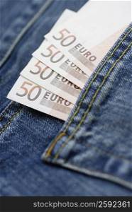 Close-up of fifty Euro banknotes tucked into a back pocket