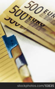 Close-up of five hundred euro banknotes on a diary