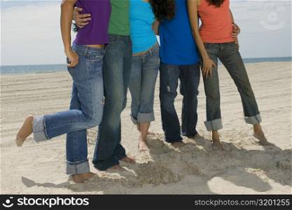 Close-up of five people standing on the beach
