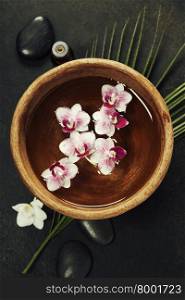 Close up of flowers floating in bowl of water and SPA setting
