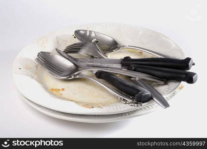 Close-up of forks and spoons with knives on a plate