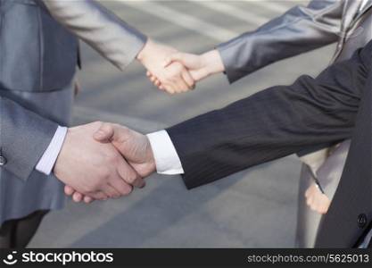 Close up of four business people shaking hands