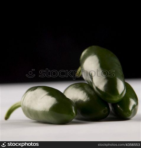 Close-up of four green chili peppers