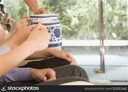 Close-up of four people&acute;s hands toasting with coffee cups
