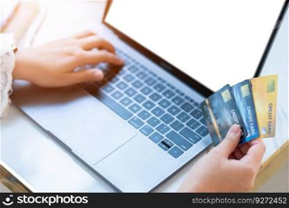 Close-up of freelance people business female Hand holding Credit cards casual working using with laptop computer empty screen in coffee shop like the background,Online payment shopping concept