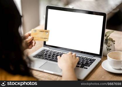 Close-up of freelance people business female Hand holding Credit cards casual working using with laptop computer with a blank white screen in coffee shop like the background,Online payment shopping