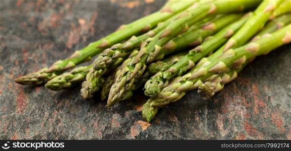 Close up of fresh asparagus on natural slate stone. Selective focus on tips of asparagus.