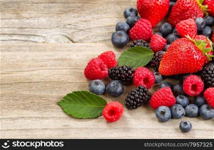 Close up of fresh berries on aged wooden boards.