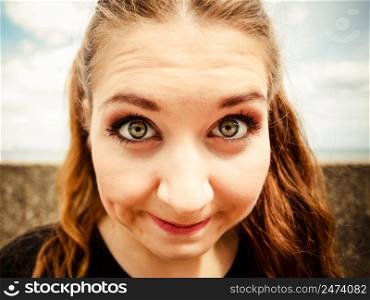 Close up of funny young teenage woman. Bizzare fish eye angle. Outdoor shot.. Close up of funny young teenage woman