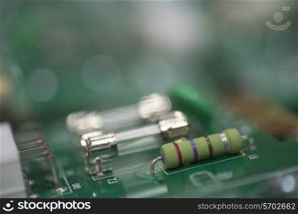 Close-up of fuse and resistor on circuit board