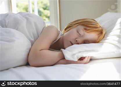 Close-up of girl (5-6) sleeping in bed