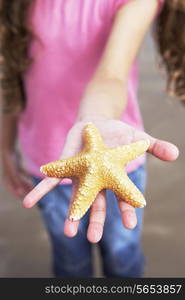 Close Up Of Girl Holding Starfish Found On Beach