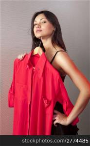 close up of girl which tries on red shirt in shop