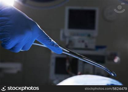 Close-up of gloved hand holding surgical scissors, operating room, hospital