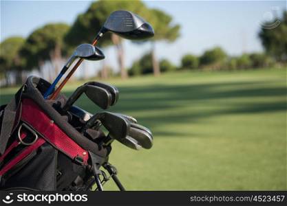 close up of golf bag on course with club and ball in front at beautiful sunrise