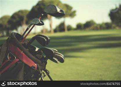 close up of golf bag on course with club and ball in front at beautiful sunrise. close up golf bag on course