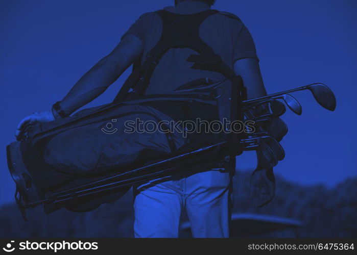 close up of golfers back while walking and carrying golf bag. close up of golfers back while carrying golf bag and walking at course to next hole duo tone