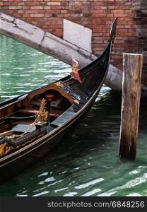 Close up of Gondola&rsquo;s Iron Prow and Antique Bridge in Venice, Italy