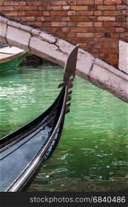 Close up of Gondola's Iron Prow and Antique Bridge in Venice, Italy