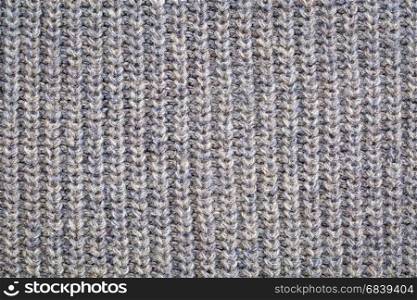 close-up of gray knitted acrylic fiber sweater texture, vertical thread patterns