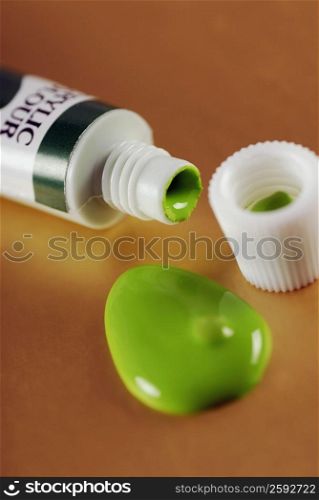 Close-up of green paint dripping from a tube