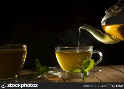 Close up of  green tea being poured from teapot into cup