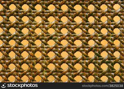 close-up of green woven rattan pattern over orange