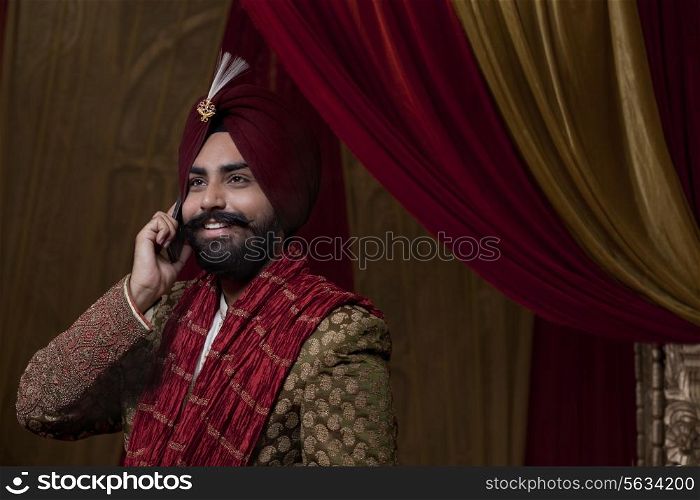 Close-up of groom having conversation on mobile phone