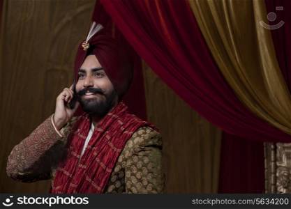Close-up of groom having conversation on mobile phone