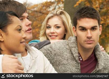 Close Up Of Group Of Four Teenage Friends In Autumn Woodland