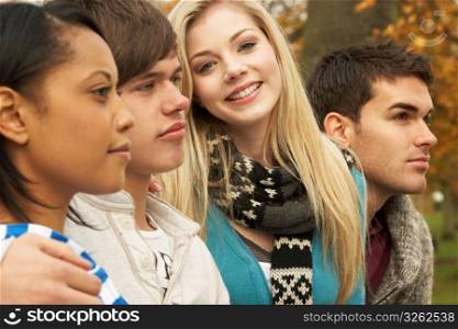 Close Up Of Group Of Four Teenage Friends In Autumn Woodland