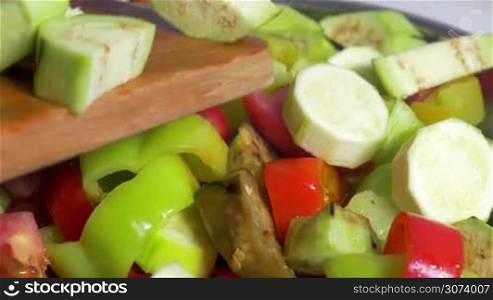 Close-up of hand adding cut vegetables in salad