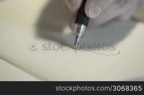 Close-up of hand drawing a cartoon woman with a black pen.