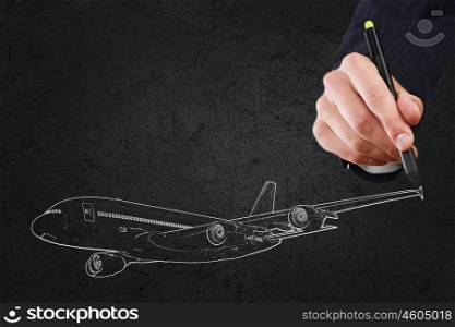 Close up of hand drawing airplane on black background. Aircraft concept