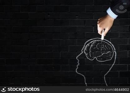 Close up of hand drawing human brain with chalk . Human brain