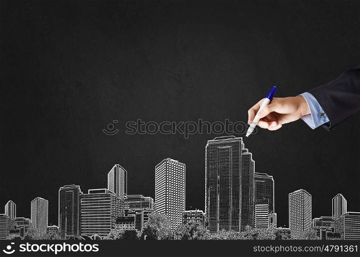 Close up of hand drawing urban city buildings. Development project