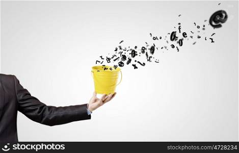 Close up of hand holding yellow bucket with letters. Communication concept
