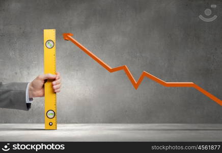 Close up of hand measuring increasing graph with ruler