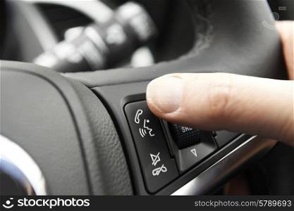 Close Up Of Hand Pressing Car Bluetooth Control On Steering Wheel