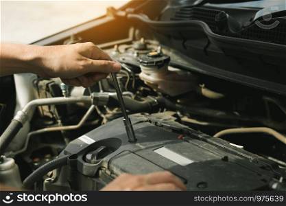Close up of hand professional mechanic repairing a car in auto repair shop.