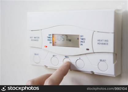 Close Up Of Hand Setting Control For Heating And Hot Water