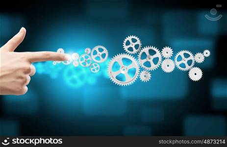 Close up of hand touching icon of gears on media screen. Working mechanism