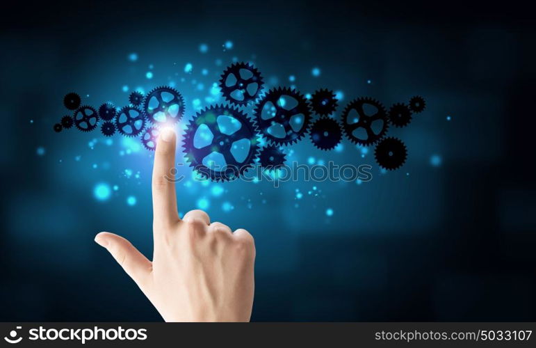 Close up of hand touching icon of gears on media screen. Working mechanism