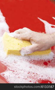 Close Up Of Hand Washing Car Hood Using Sponge