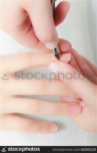 Close up of hands. Beautician trimming cuticles of female client. Manicure and skincare. Woman in spa beauty salon.